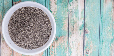 Black pepper powder in white bowl over wooden backgroundの写真素材