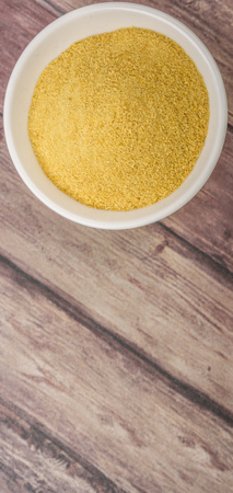 Dried bakers yeast in wooden bowl over wooden backgroundの写真素材