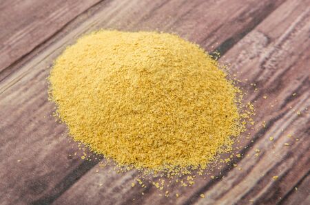 Dried bakers yeast over wooden background