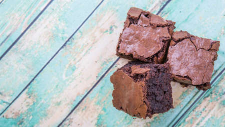 Homemade chocolate brownies over wooden background