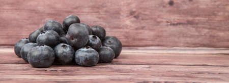 Blueberry fruit over wooden background