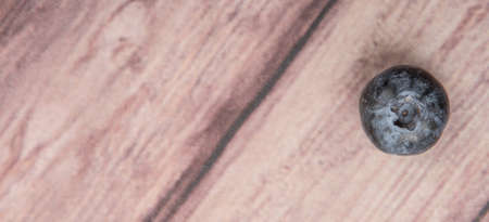 Blueberry fruit over wooden background