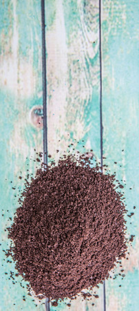 Fresh grounded coffee over wooden background