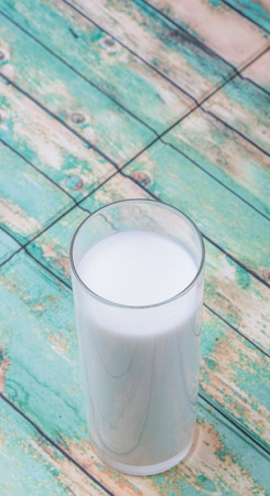 A fresh glass of fresh milk over wooden backgroundの写真素材