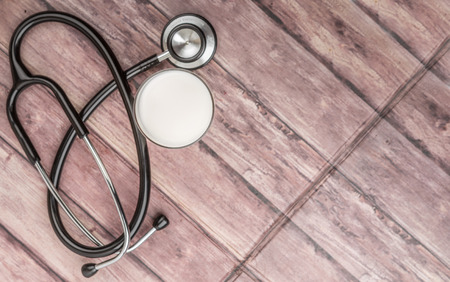 Stethoscope and a glass of milk over wooden background. Healthy lifestyle concept.の写真素材