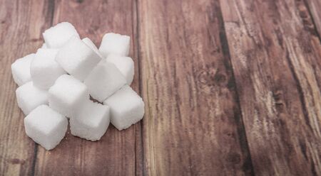 Sugar cubes over wooden background