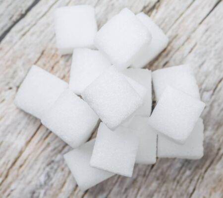 Sugar cubes over wooden background