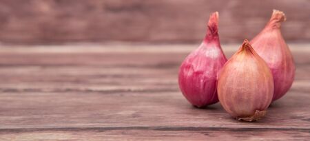 Shallots over wooden backgroundの写真素材