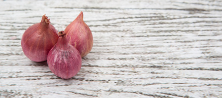 Shallots over wooden backgroundの写真素材