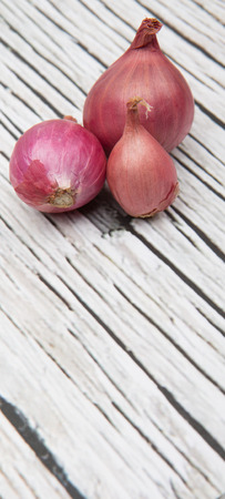 Shallots over wooden backgroundの写真素材