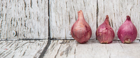 Shallots over wooden backgroundの写真素材