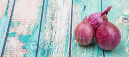 Shallots over wooden backgroundの写真素材