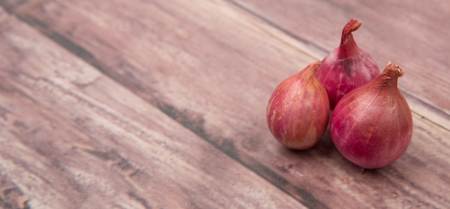 Shallots over wooden backgroundの写真素材