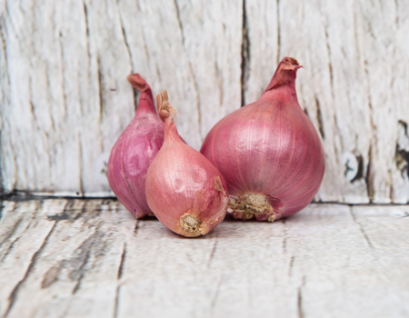 Shallots over wooden backgroundの写真素材