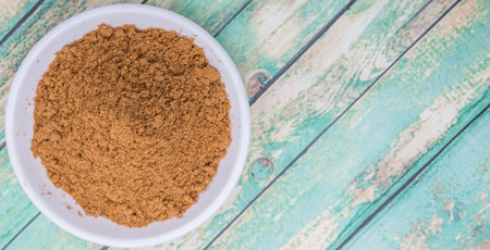 Garam masala or mix spices blend in white bowl over wooden backgroundの写真素材