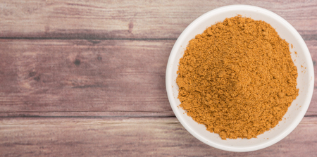 Garam masala or mix spices blend in white bowl over wooden backgroundの写真素材