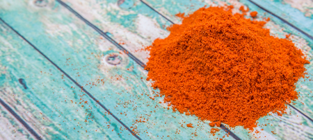 Cayenne pepper powder over wooden background