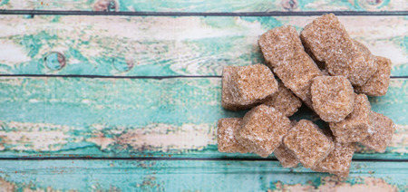 Brown sugarcane sugar cube over wooden background