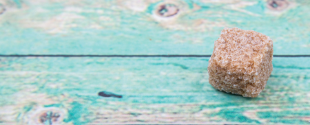 Brown sugarcane sugar cube over wooden background