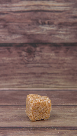 Brown sugarcane sugar cube over wooden backgroundの写真素材