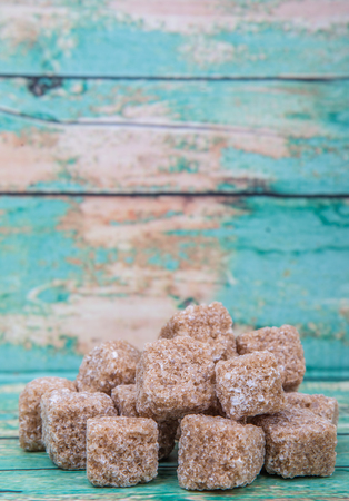 Brown sugarcane sugar cube over wooden backgroundの写真素材