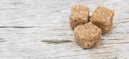 Brown sugarcane sugar cube over wooden backgroundの写真素材