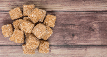 Brown sugarcane sugar cube over wooden backgroundの写真素材