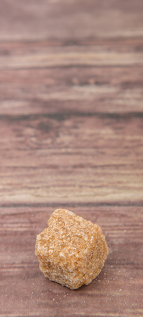 Brown sugarcane sugar cube over wooden backgroundの写真素材