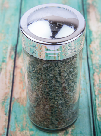 Marjoram herbs in spice dispenser over wooden backgroundの写真素材