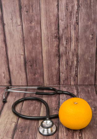 Medical stethoscope with an orange fruit. Healthy lifestyle concept imageの写真素材