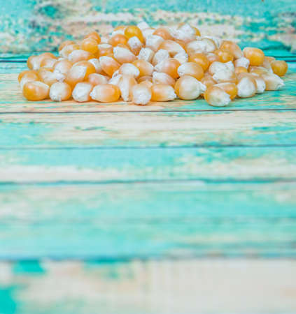 Raw popcorn over wooden background