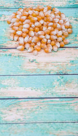 Raw popcorn over wooden background