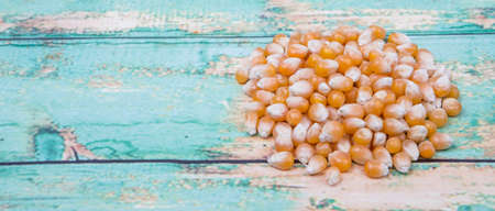 Raw popcorn over wooden background