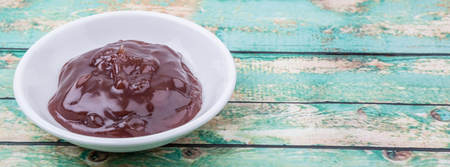 Raspberry fruit curd in white bowl over wooden backgroundの写真素材