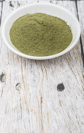 Peppermint herbs powder in white bowl over wooden backgroundの写真素材