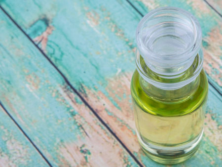 Grape seed oil in glass vial over wooden backgroundの写真素材