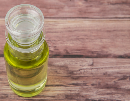 Grape seed oil in glass vial over wooden background