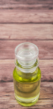 Grape seed oil in glass vial over wooden backgroundの写真素材
