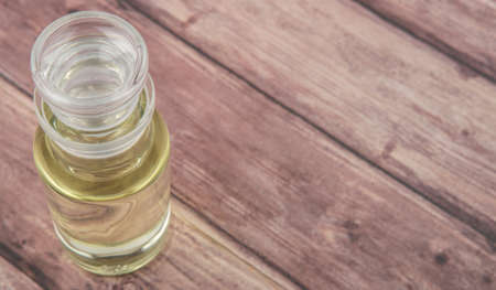 Corn vegetable cooking oil in vial glass over wooden background