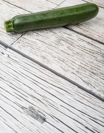 Green zucchini over wooden backgroundの写真素材