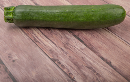 Green zucchini over wooden backgroundの写真素材