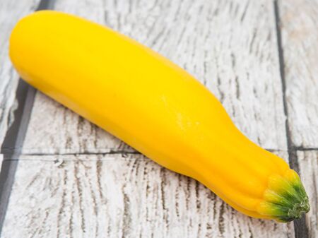 Yellow zucchini over wooden backgroundの写真素材