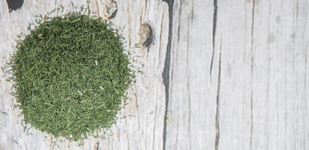 Dried dill herbs over rustic wooden background