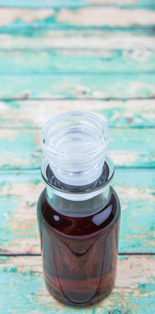 Maple vinegar in glass vial over wooden backgroundの写真素材