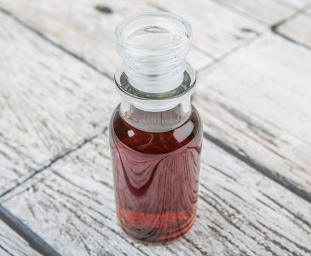 Maple vinegar in glass vial over wooden backgroundの写真素材