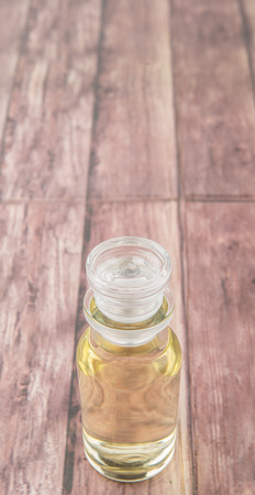 Apple vinegar in glass vial over wooden backgroundの写真素材