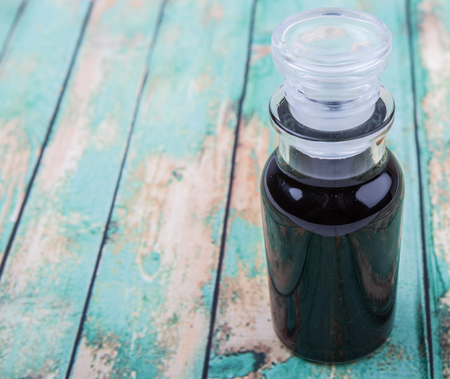 Italian balsamic vinegar in glass vial over wooden backgroundの写真素材