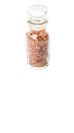 Himalaya or Himalayan rock salt in glass vial over white backgroundの写真素材
