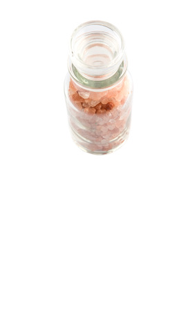 Himalaya or Himalayan rock salt in glass vial over white backgroundの写真素材