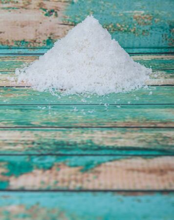 Dried coconut powder over wooden background